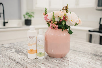 True green Organics All Purpose Cleaner and Lemon Lime Dish washing Soap bottles next to pink vase with flowers