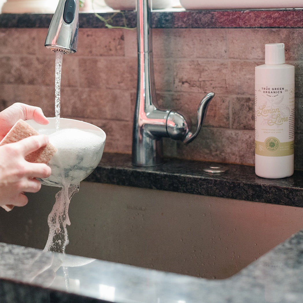 Washing a bowl with True Green Organics Dish washing soap Lemon Lime Bottles 8oz and 16oz